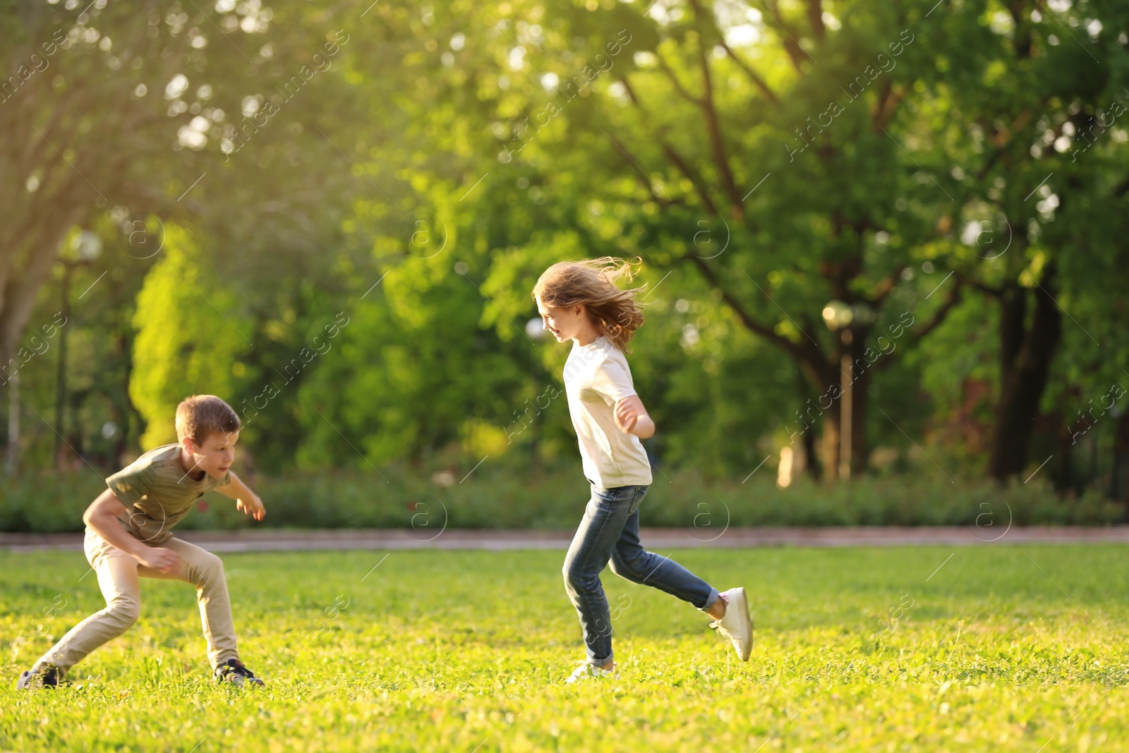 Photo of Cute little children playing together outdoors on sunny day