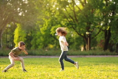 Photo of Cute little children playing together outdoors on sunny day