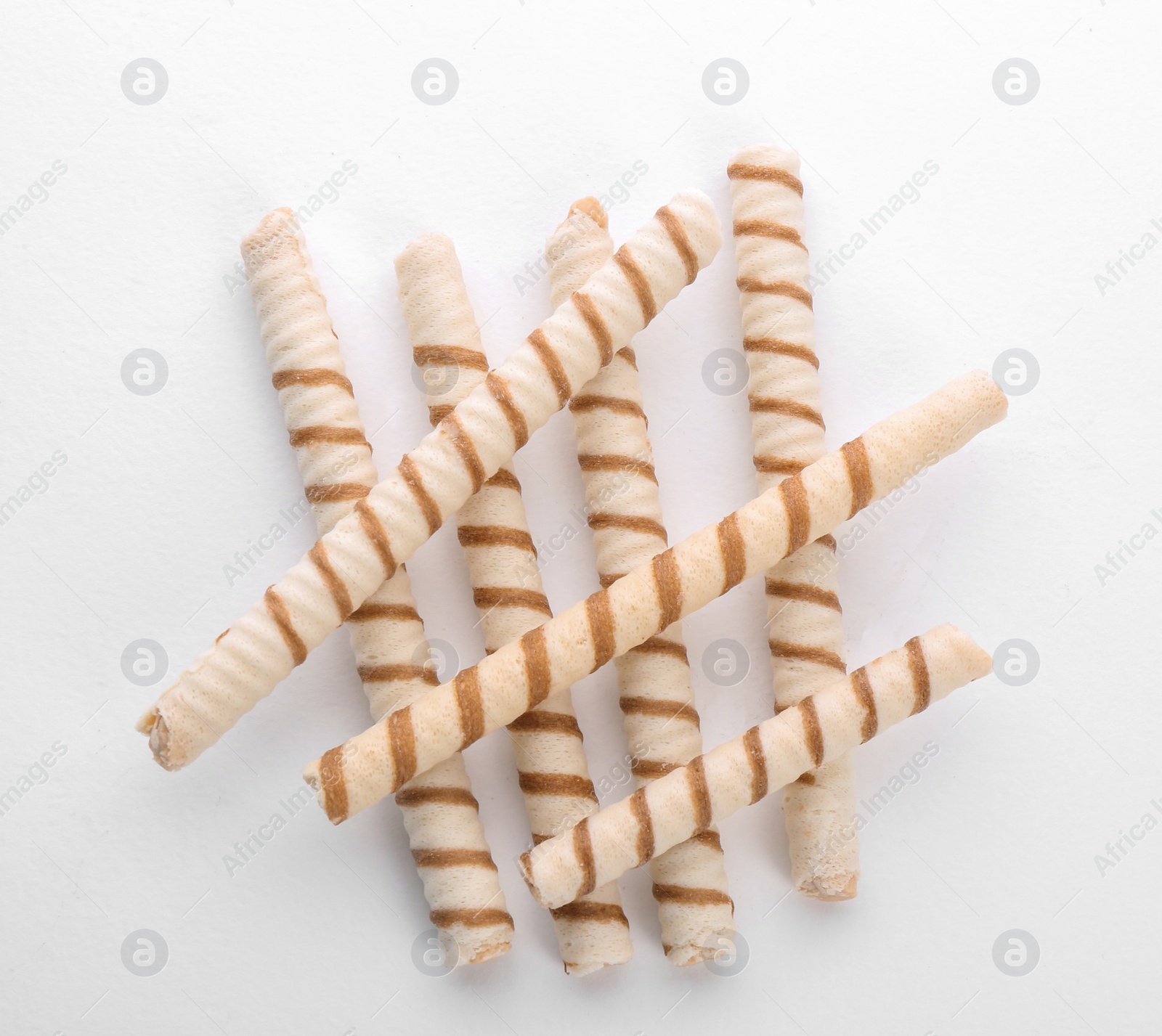 Photo of Tasty wafer roll sticks on white background, top view. Crispy food