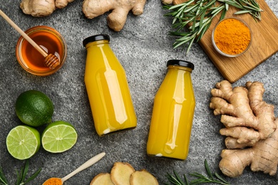 Photo of Flat lay composition with immunity boosting drink in bottles on grey table