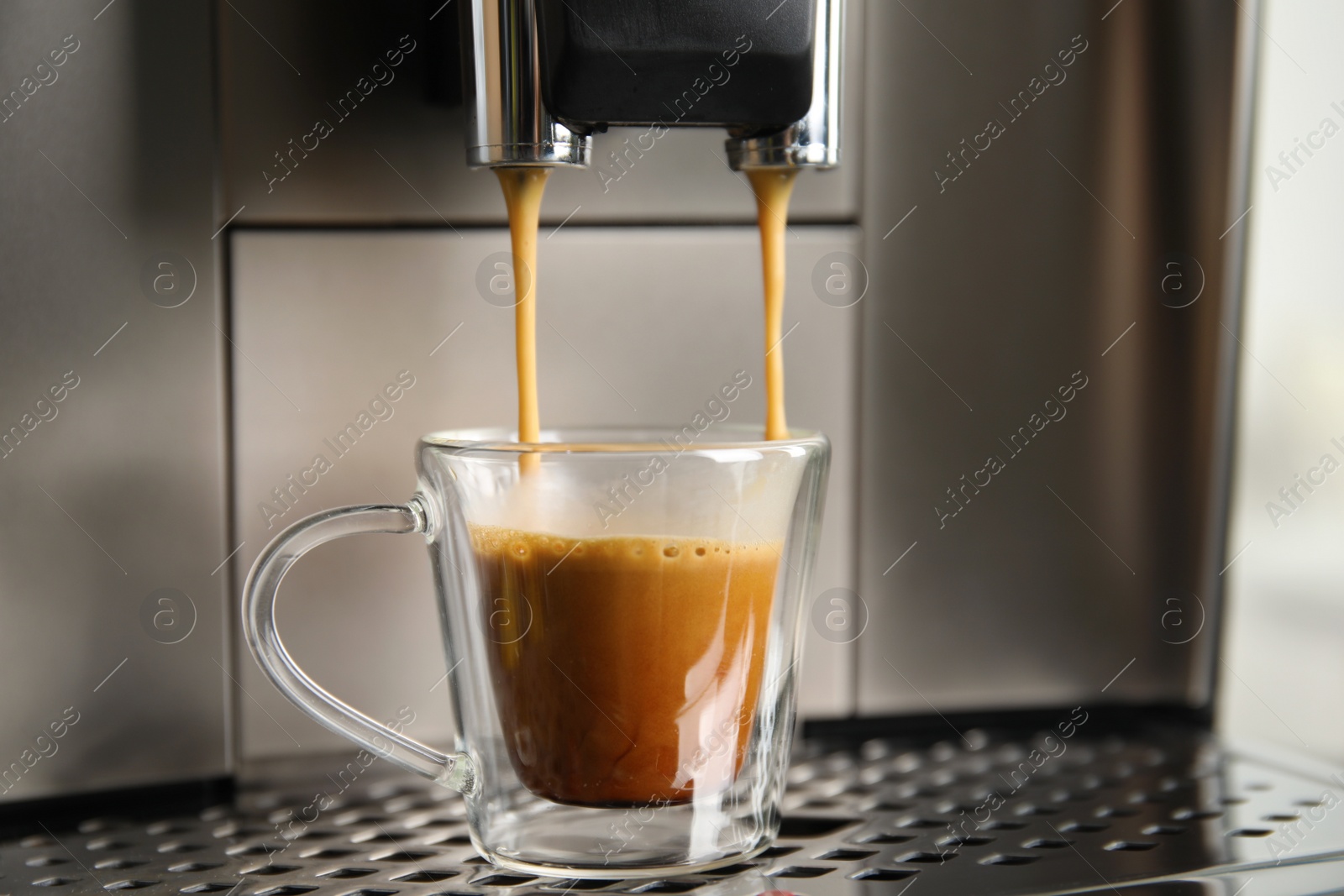 Photo of Espresso machine pouring coffee into glass cup, closeup
