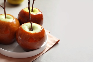 Photo of Plate with delicious green caramel apples on table