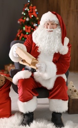 Photo of Authentic Santa Claus reading wish list indoors