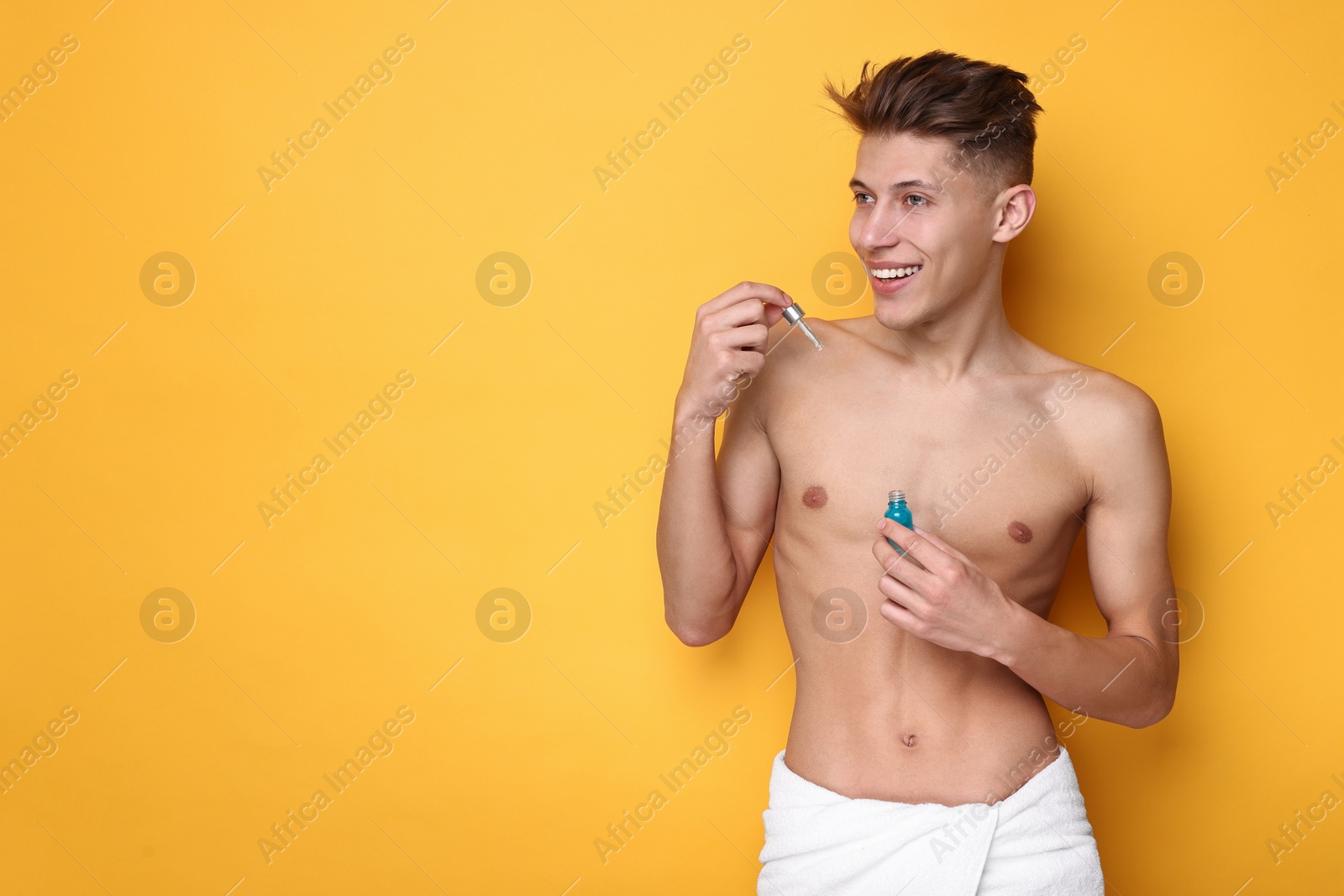 Photo of Handsome man with serum on orange background. Space for text