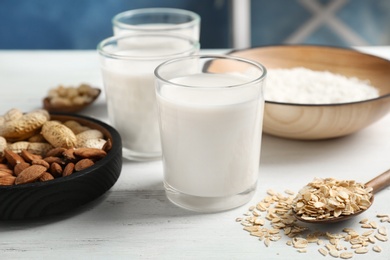 Glasses with different types of milk on wooden table