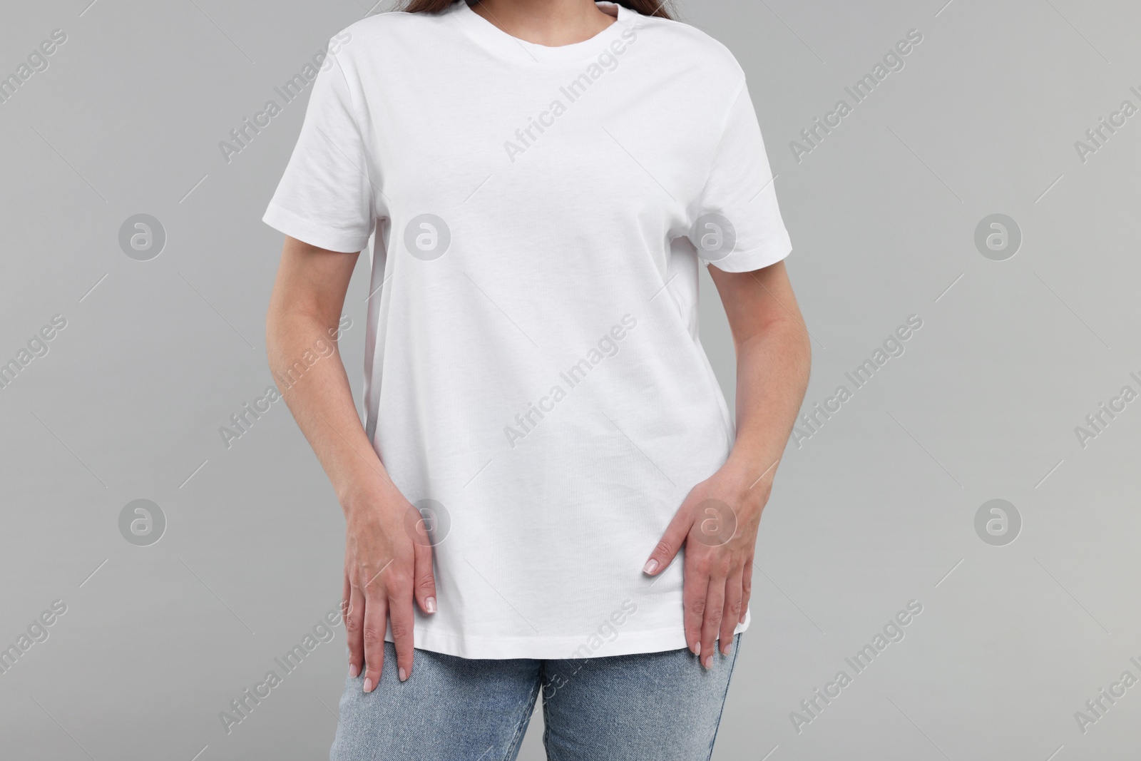 Photo of Woman in white t-shirt on grey background, closeup