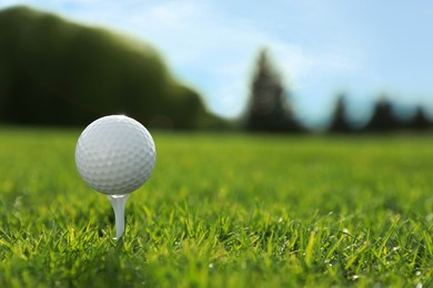 Photo of Golf ball on tee at green course, space for text