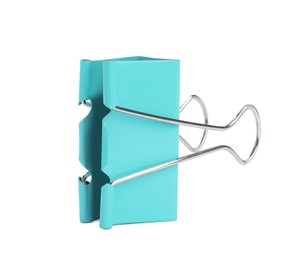 Photo of Turquoise binder clip isolated on white. Stationery