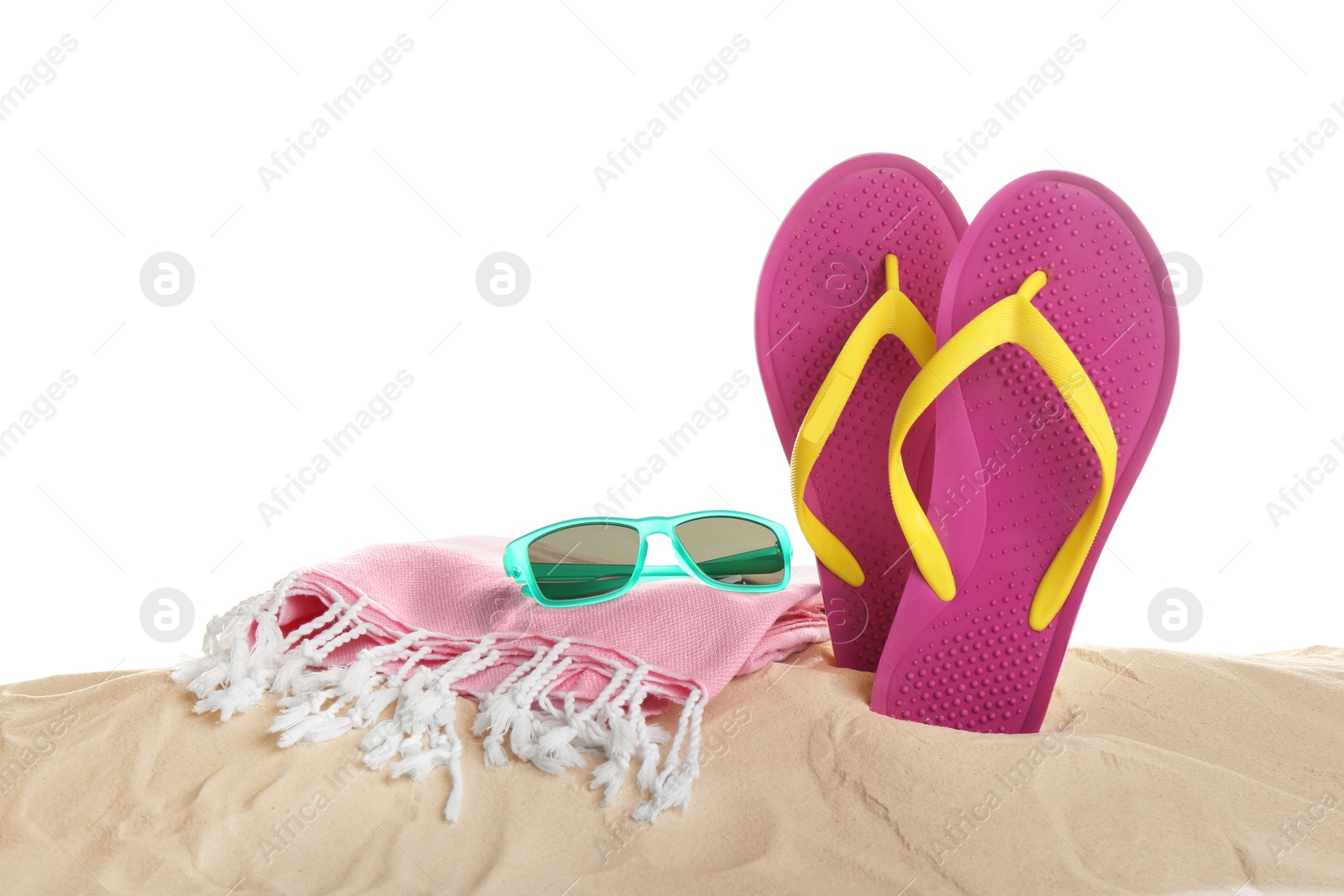 Photo of Sunglasses, flip flops and towel on sand against white background. Beach accessories