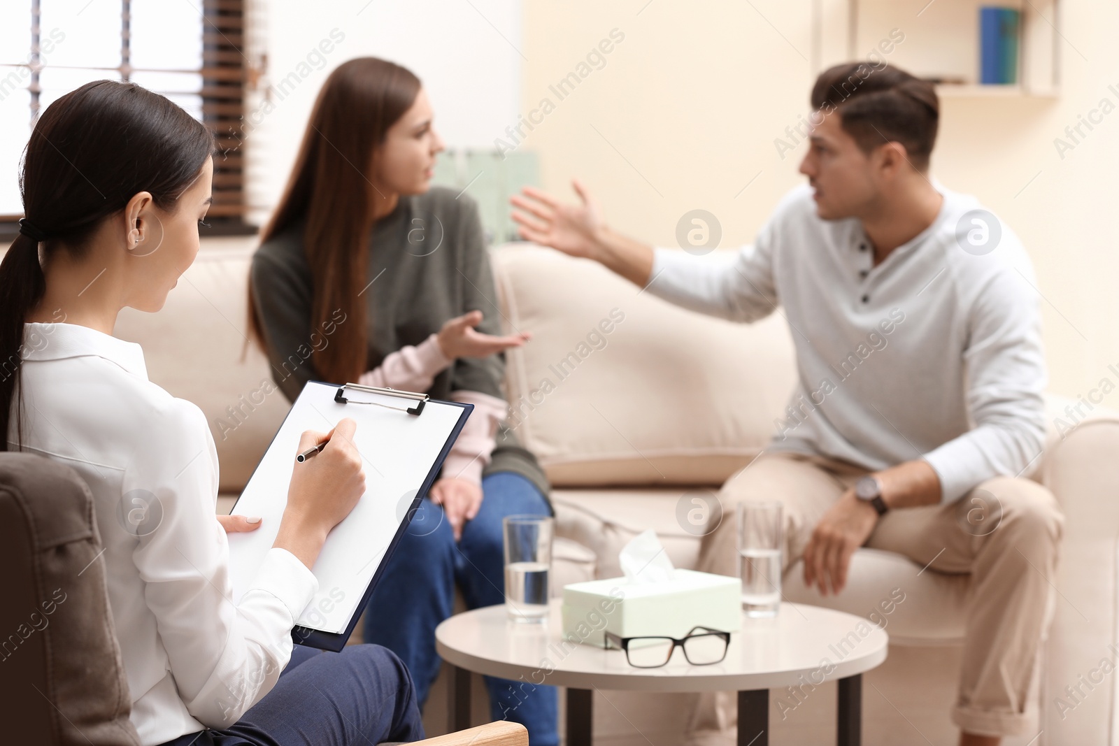 Photo of Professional psychologist working with couple in office