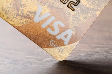 Photo of MYKOLAIV, UKRAINE - FEBRUARY 23, 2022: Bank card of Visa payment system on wooden table, closeup
