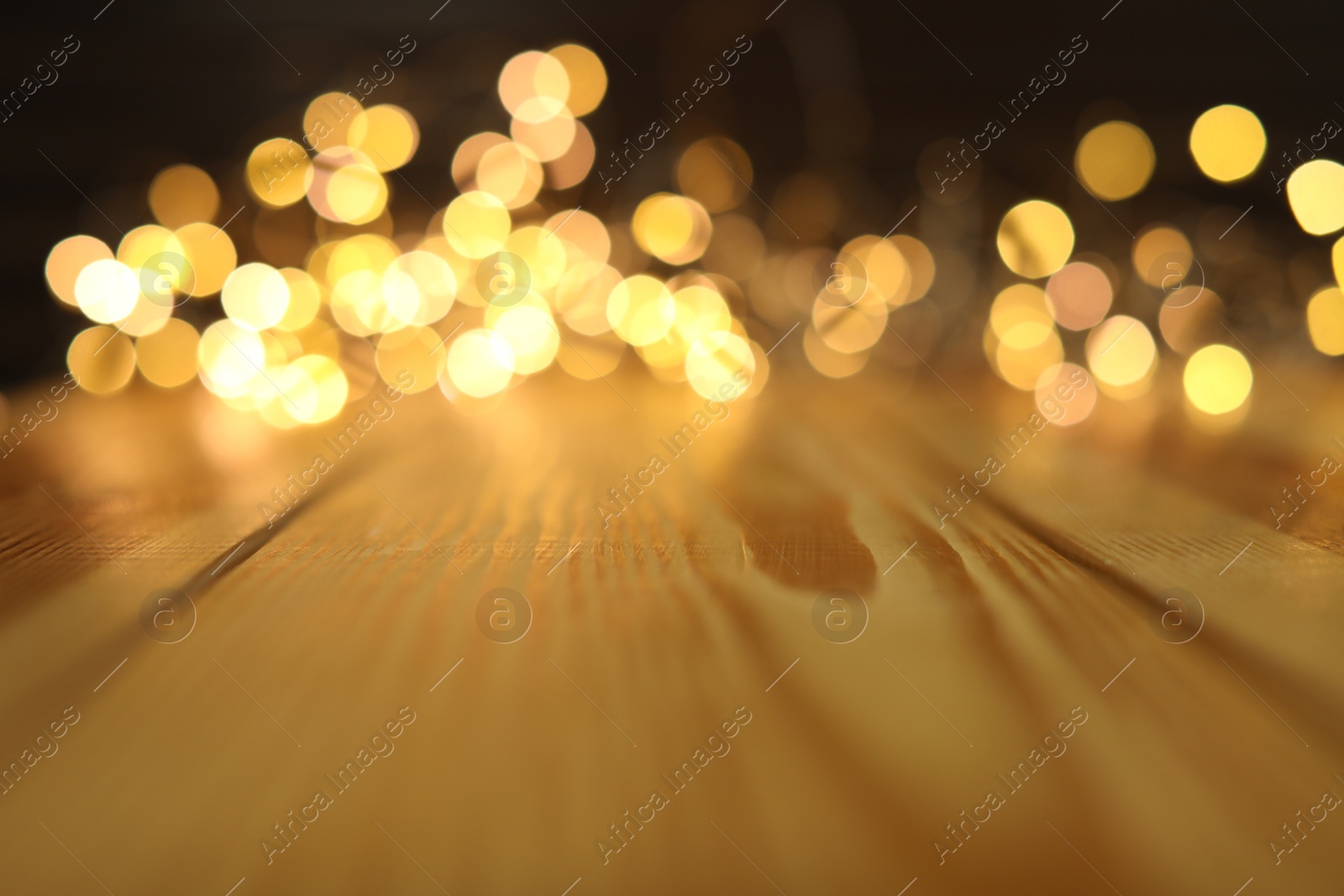 Photo of Empty wooden surface and blurred lights on background. Bokeh effect