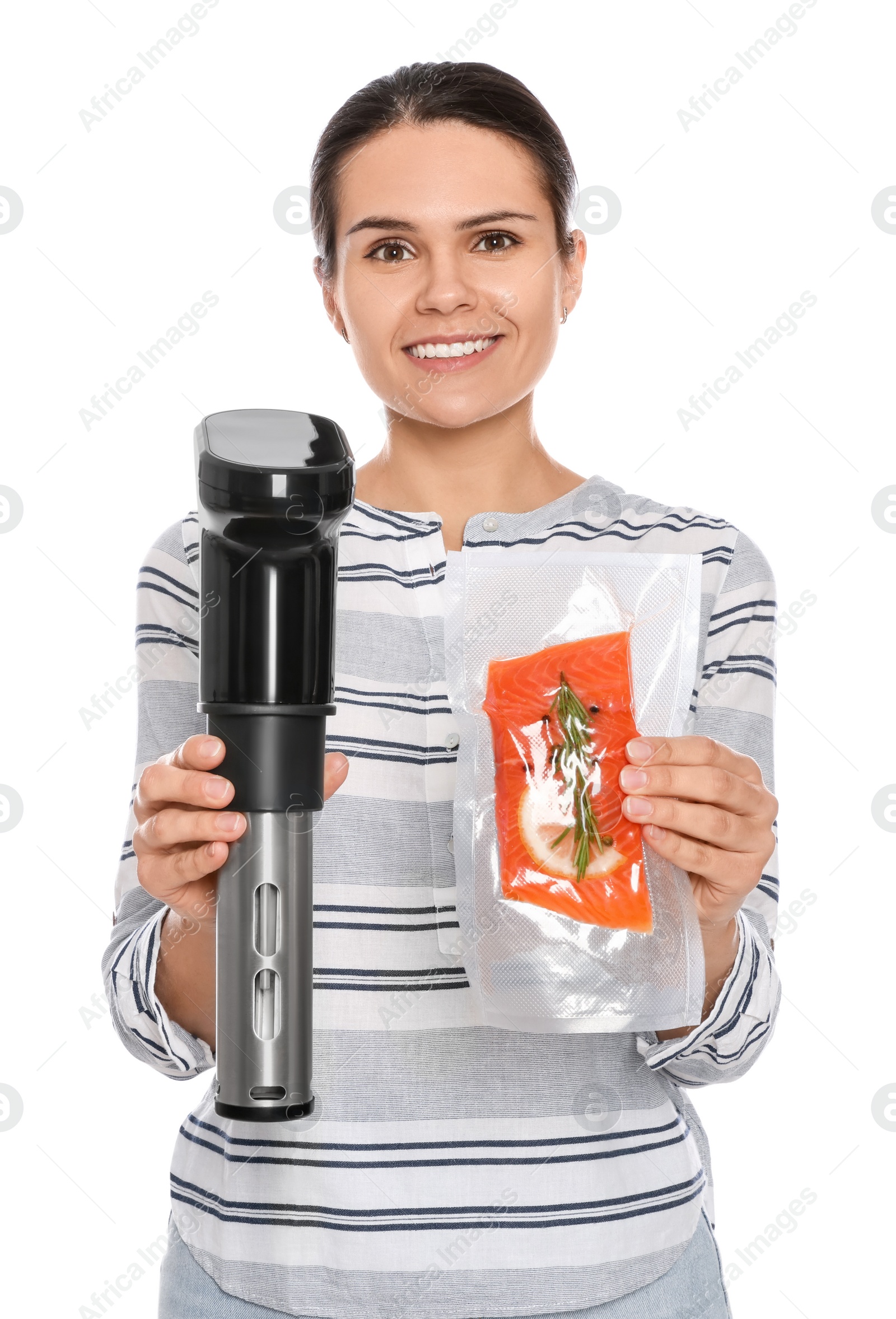 Photo of Beautiful young woman holding sous vide cooker and salmon in vacuum pack on white background