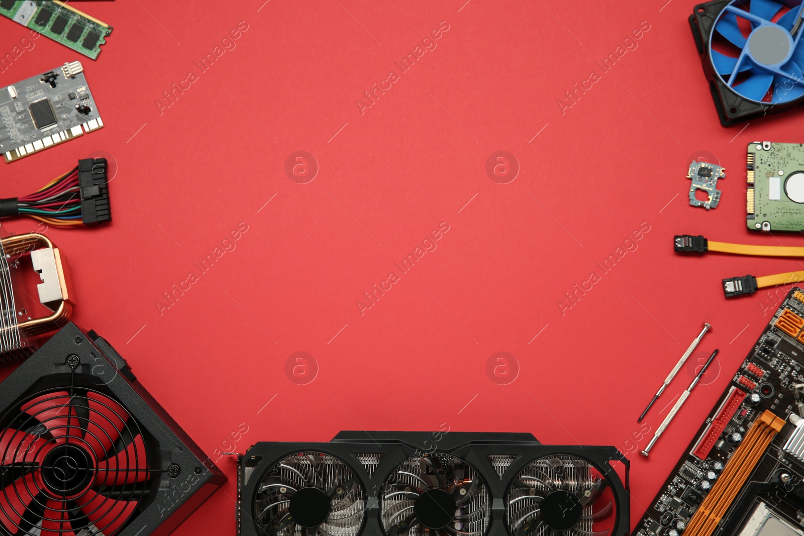 Photo of Graphics card and other computer hardware on red background, flat lay. Space for text