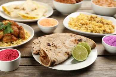 Traditional Indian food and color powders on wooden table. Holi festival celebration