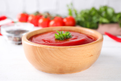 Photo of Delicious tomato sauce on white wooden table, closeup