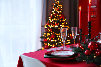 Photo of Table served for festive dinner and Christmas tree in stylish kitchen interior