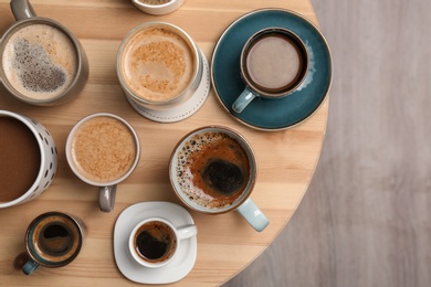 Many cups of different aromatic hot coffee on table, top view