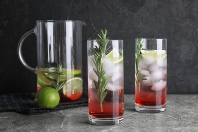 Photo of Tasty refreshing lime cocktail with rosemary on table
