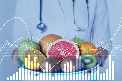 Nutritionist holding plate with ripe fruits and illustration of charts. Healthy eating