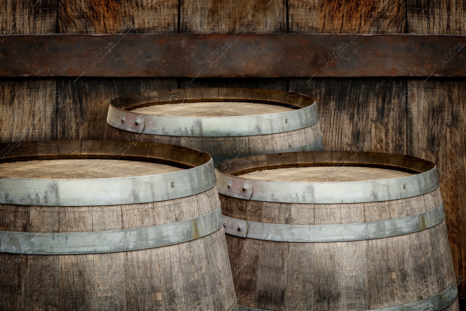 Image of Three wooden barrels near old textured wall