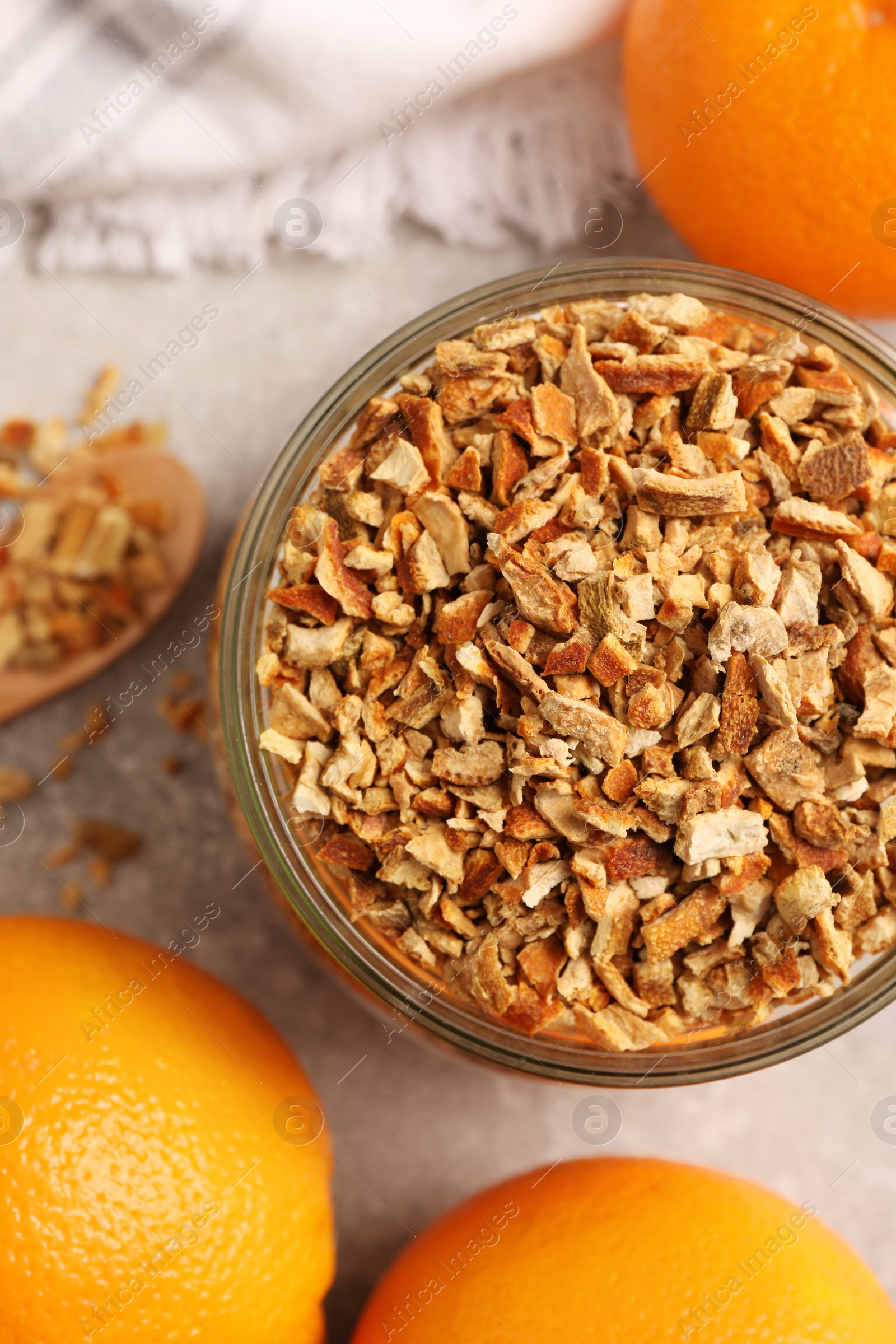 Photo of Jar of dried orange zest seasoning and fresh fruits on light grey table, flat lay