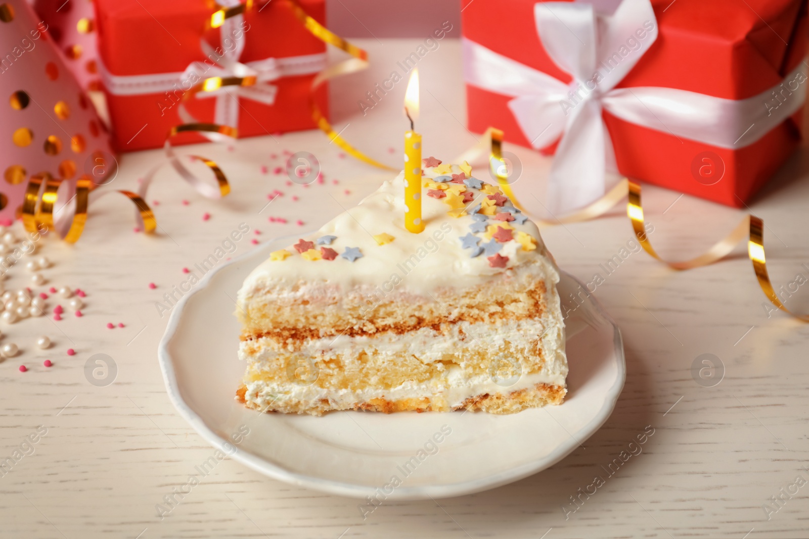 Photo of Slice of delicious birthday cake with candle on table