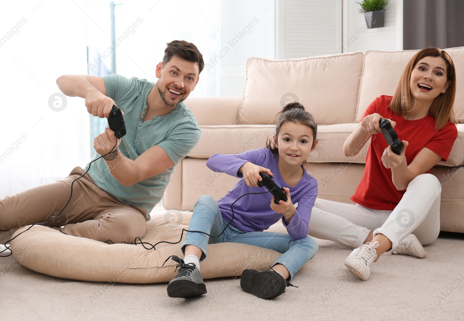 Photo of Happy family playing video games in living room