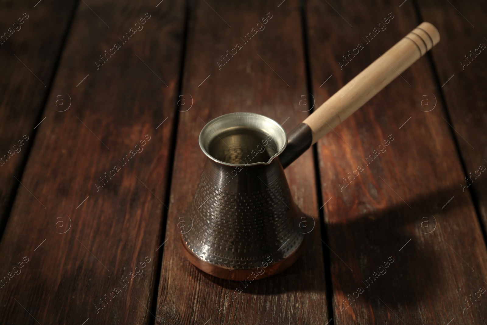 Photo of Beautiful copper turkish coffee pot on wooden table