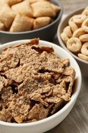 Photo of Different breakfast cereals in bowls on table, closeup