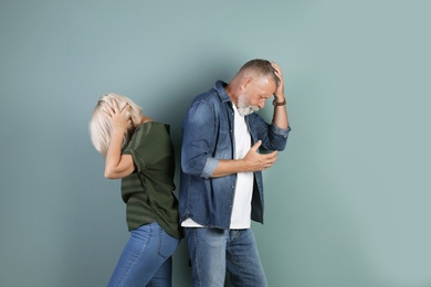 Photo of Upset mature couple on color background. Relationship problems