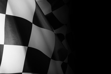 Photo of Checkered finish flag on black background, closeup