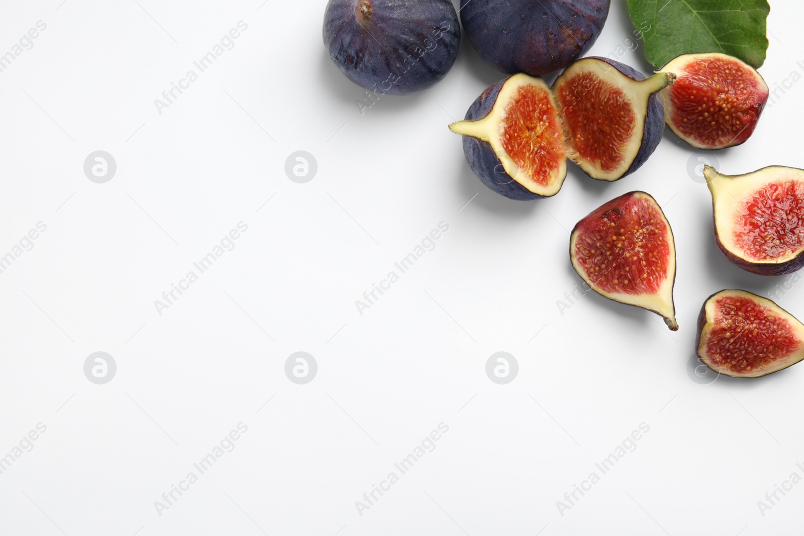 Photo of Delicious ripe figs with green leaf on white background, top view