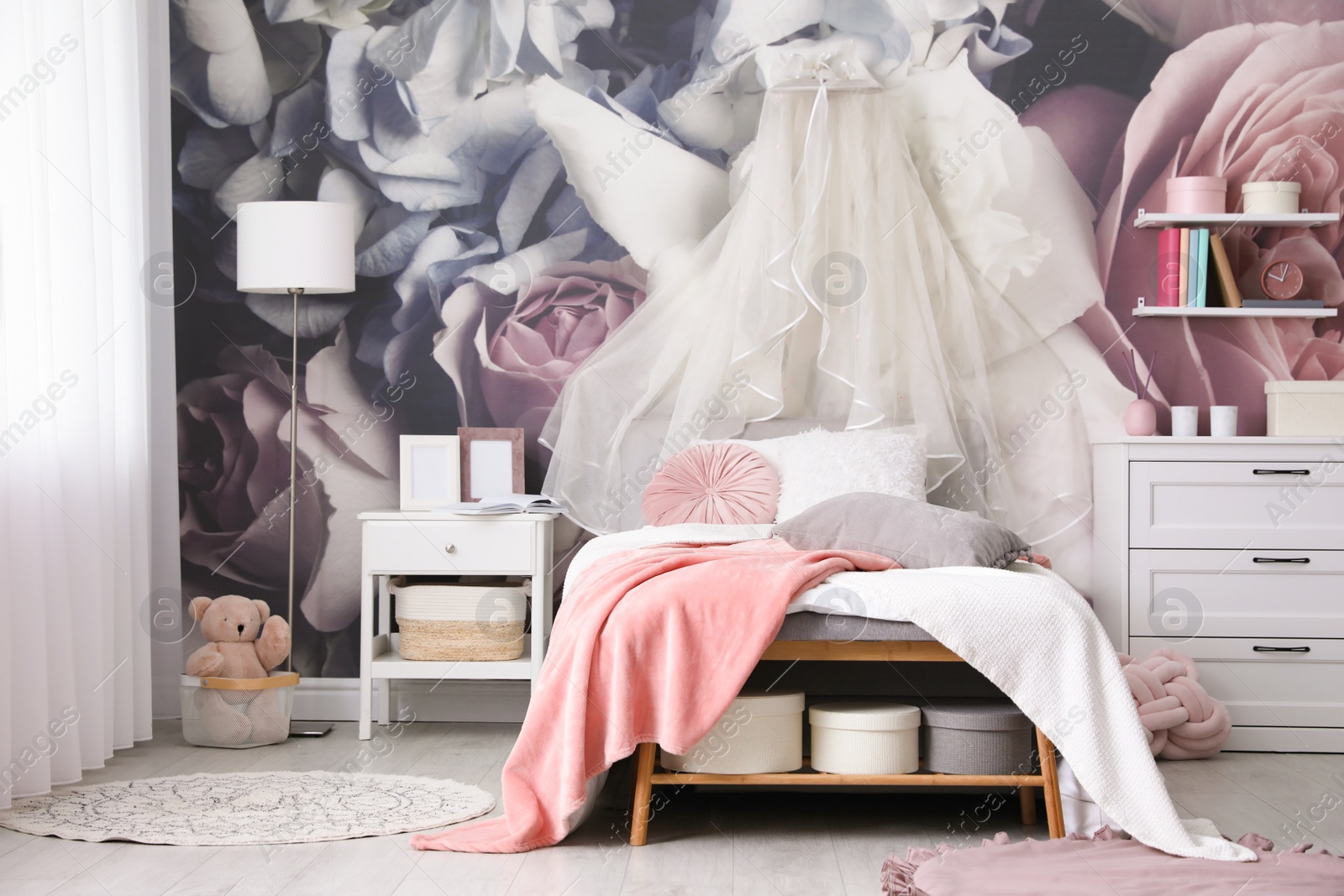 Photo of Teenage girl's room interior with comfortable bed and floral wallpaper. Idea for stylish design