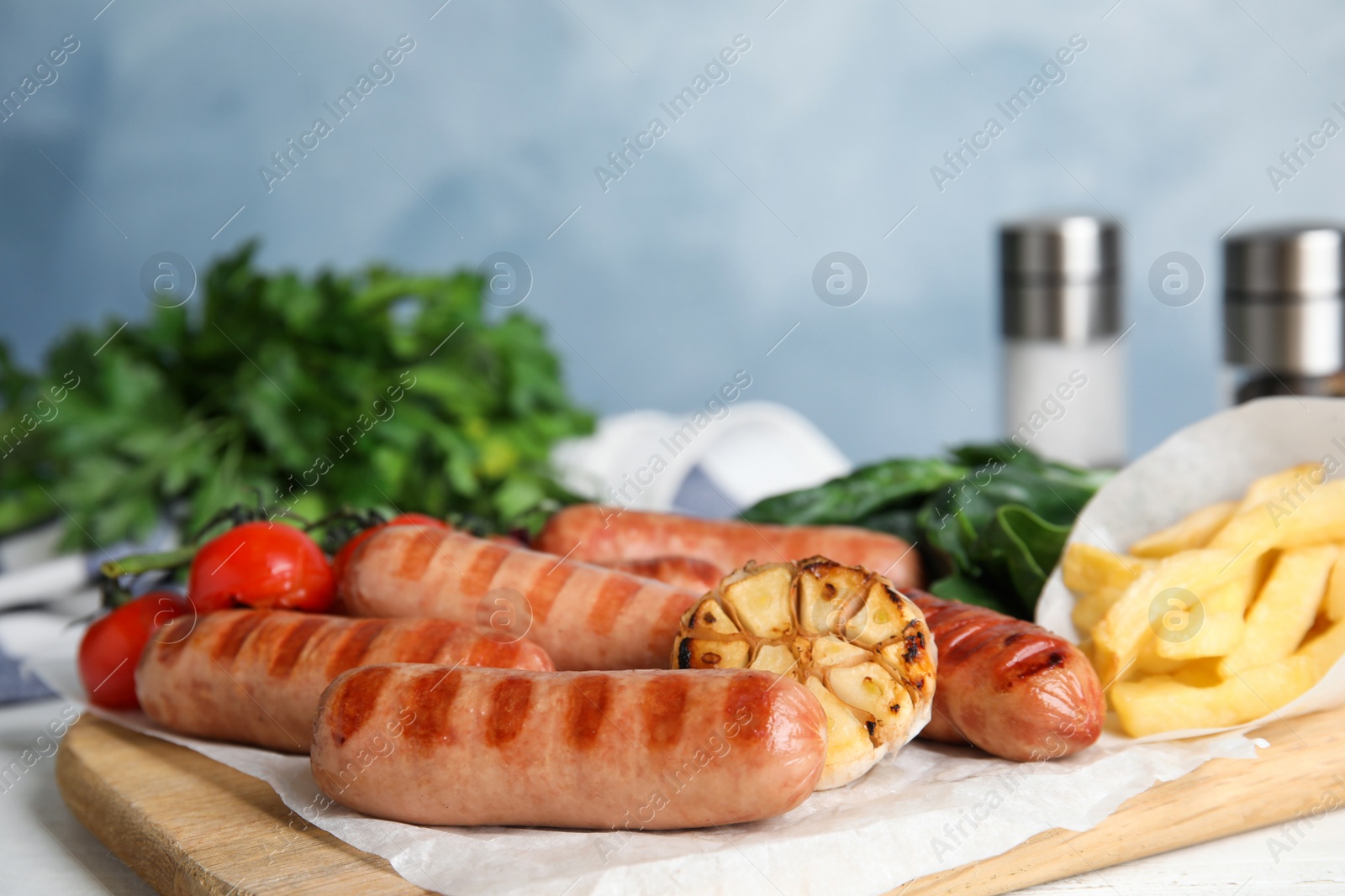 Photo of Delicious grilled sausages served on white table