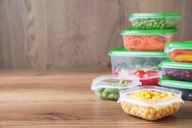 Photo of Set of plastic containers with fresh food on wooden  table, space for text