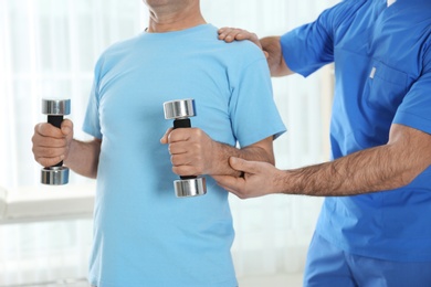 Doctor working with patient in hospital, closeup. Rehabilitation exercises