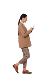 Photo of Young businesswoman using smartphone while walking on white background