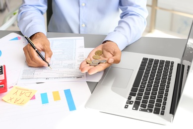 Photo of Tax accountant with money and documents at table