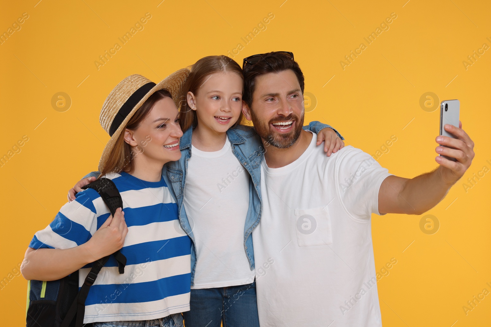 Photo of Happy family taking selfie on orange background