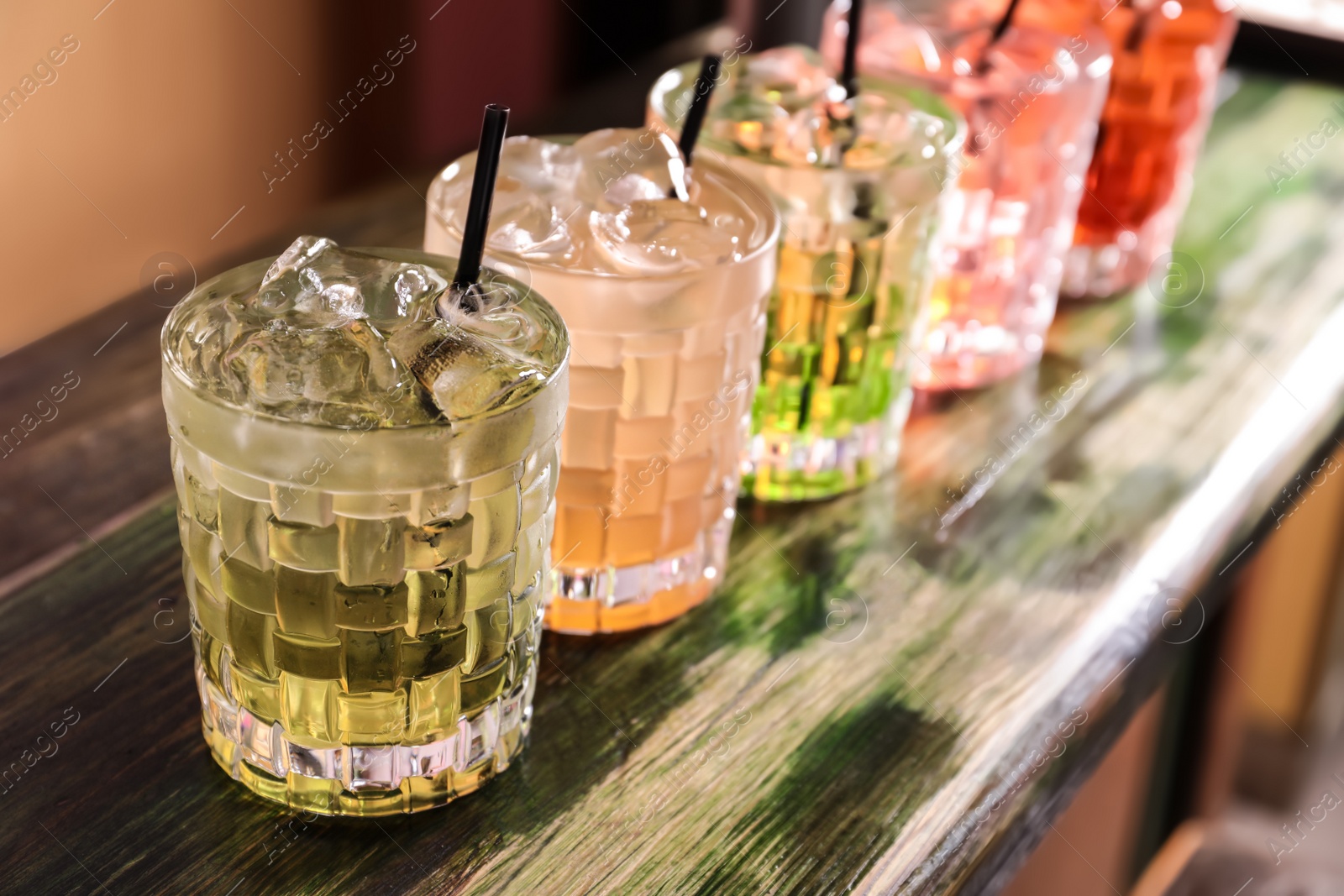 Photo of Glasses of delicious cocktails with ice on table