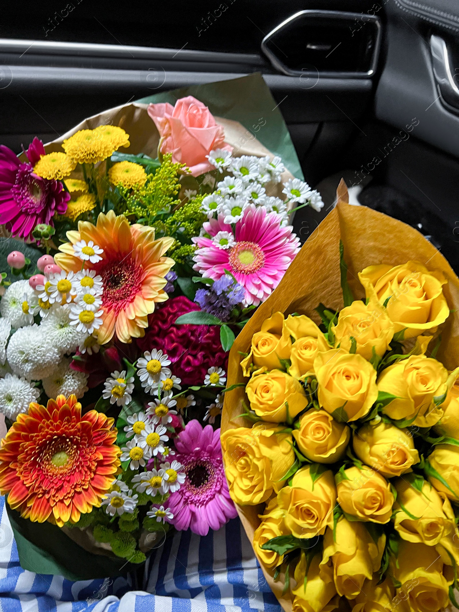 Photo of Woman with different bouquets of beautiful flowers in car, closeup