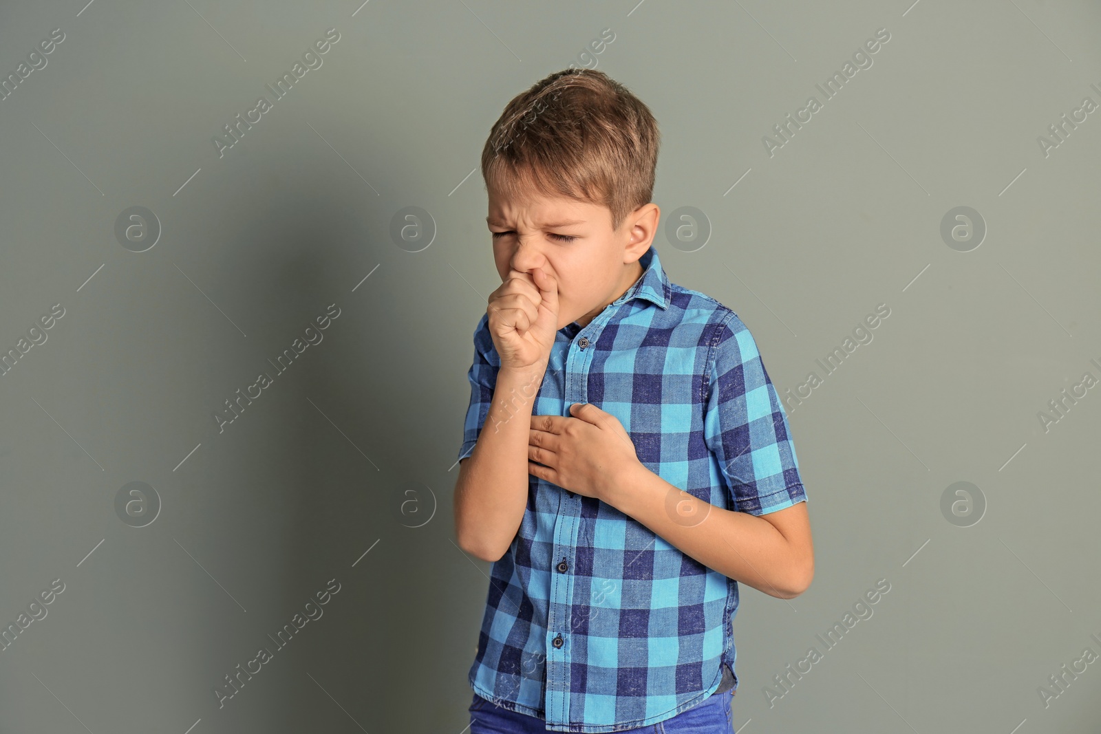 Photo of Little boy coughing on color background