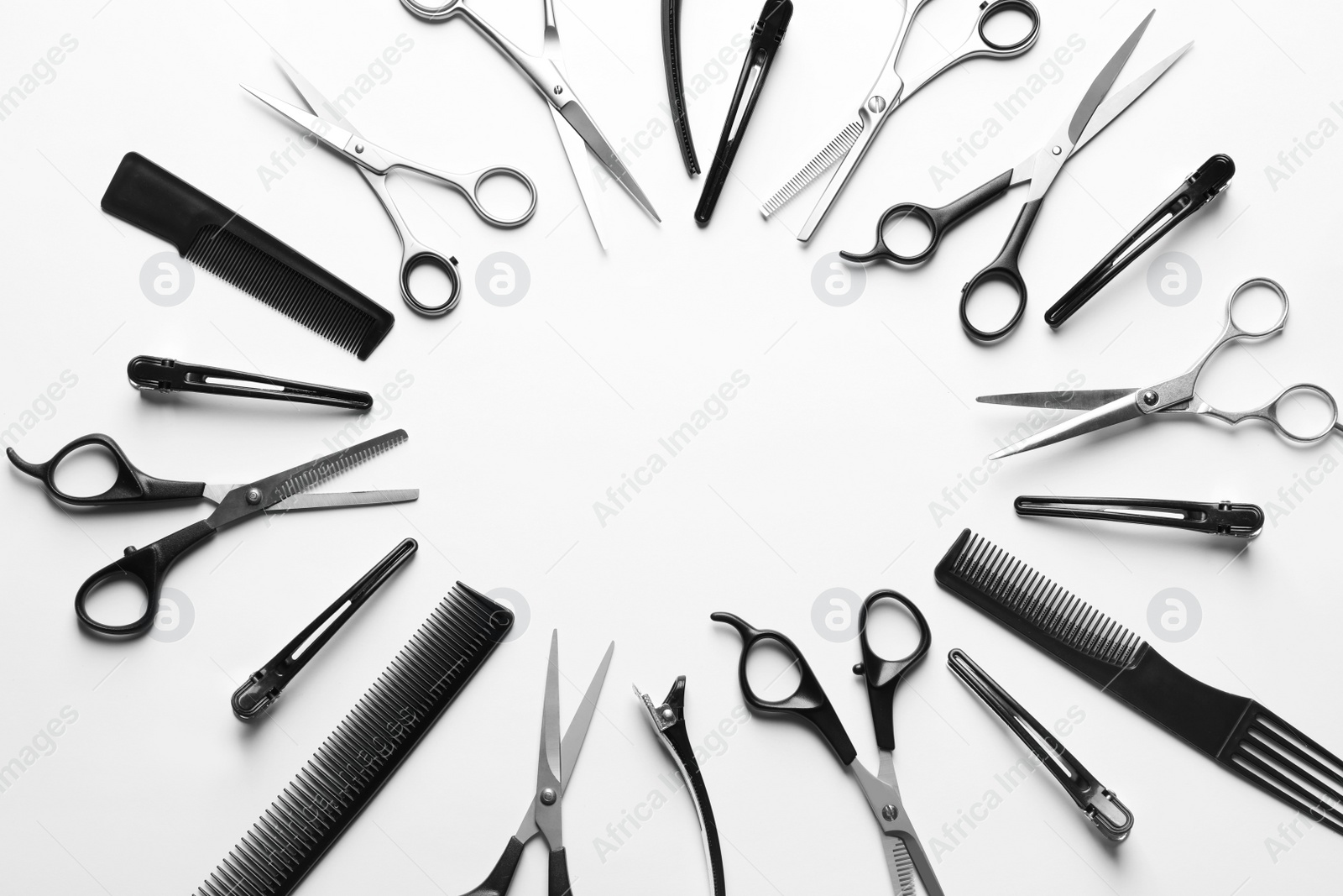 Photo of Frame made of scissors and other hairdresser's accessories on white background, top view. Space for text