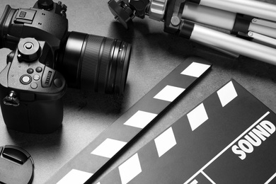 Photo of Clapboard with camera and tripod on grey background. Video production industry