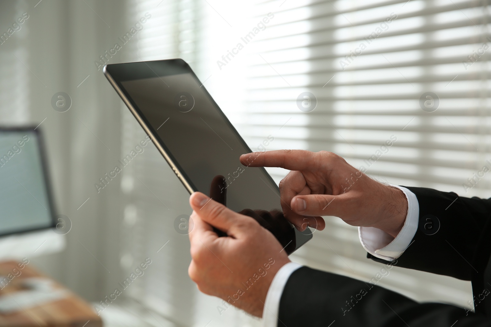 Photo of Businessman using modern tablet in office, closeup