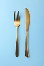 Stylish cutlery on light blue table, top view