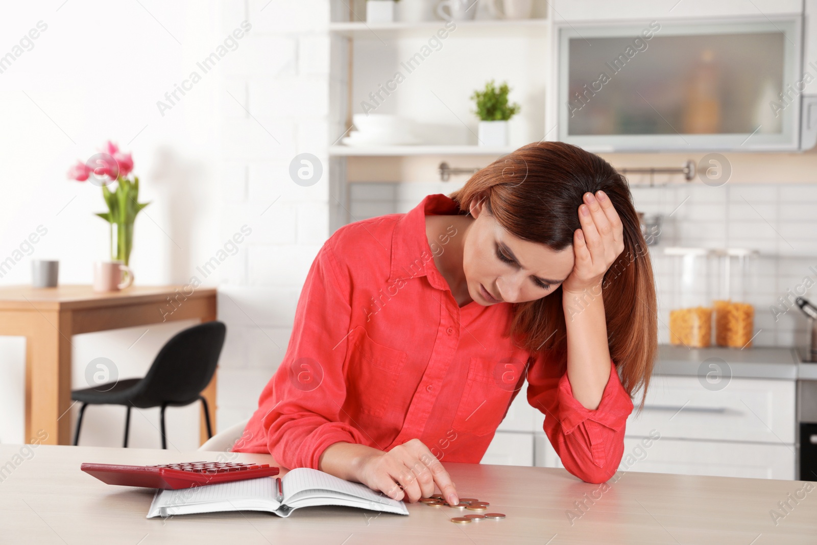 Photo of Sad woman counting money at table indoors