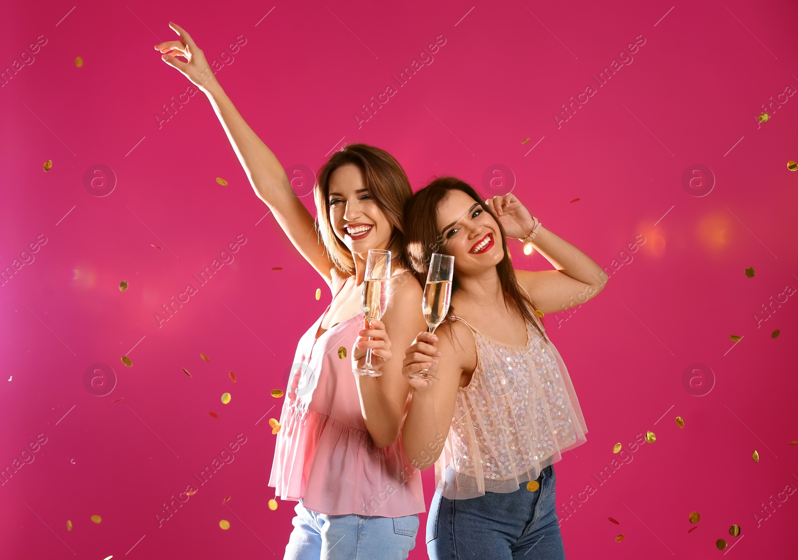 Photo of Portrait of happy friends with champagne in glasses and confetti on color background