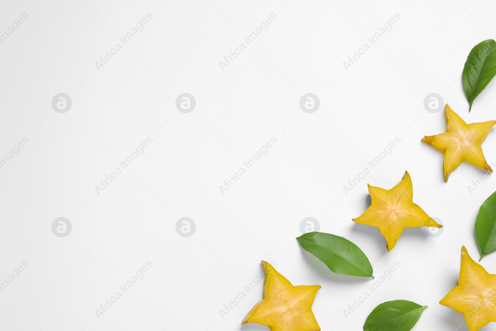 Photo of Flat lay composition with cut carambola on white background. Space for text